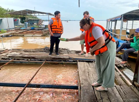 Croisière en bateau à moteur sur le Mékong près de la ferme piscicole flottante