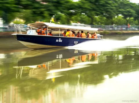 VIP speedboat cruising a narrow canal on the Mekong Delta speedboat tour